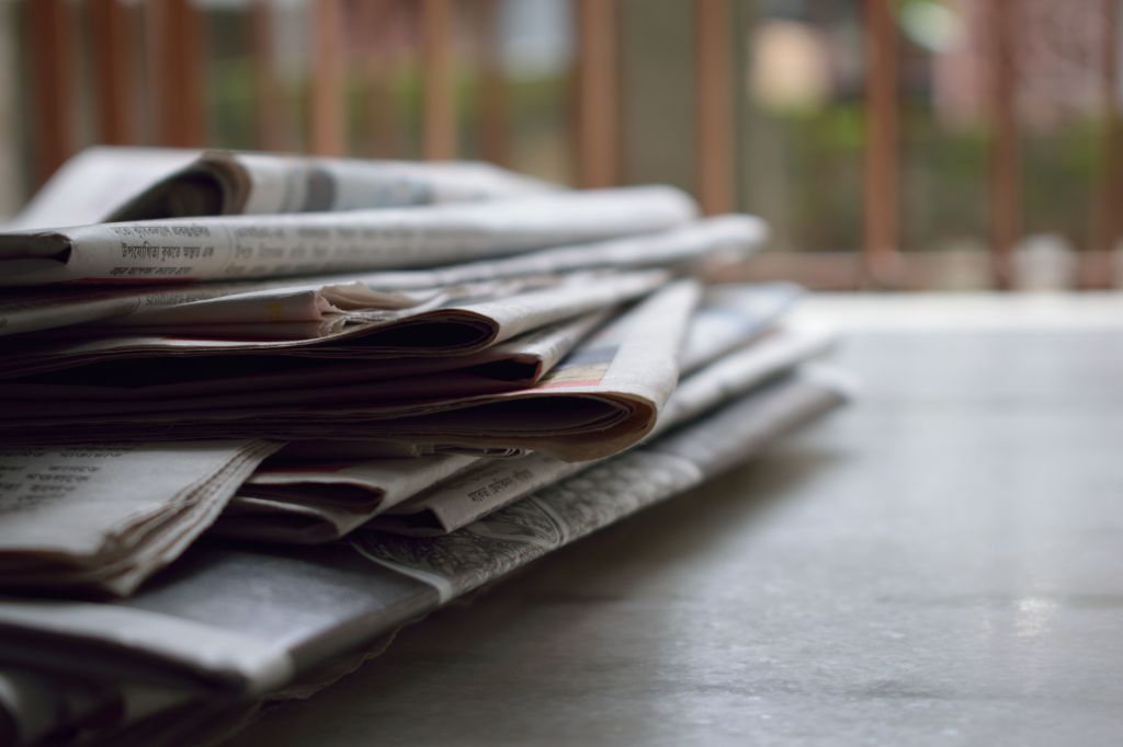 Stack of newspapers representing local press coverage