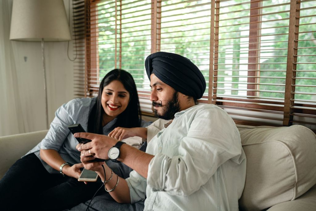 Two people on a couch watching a video on a smartphone