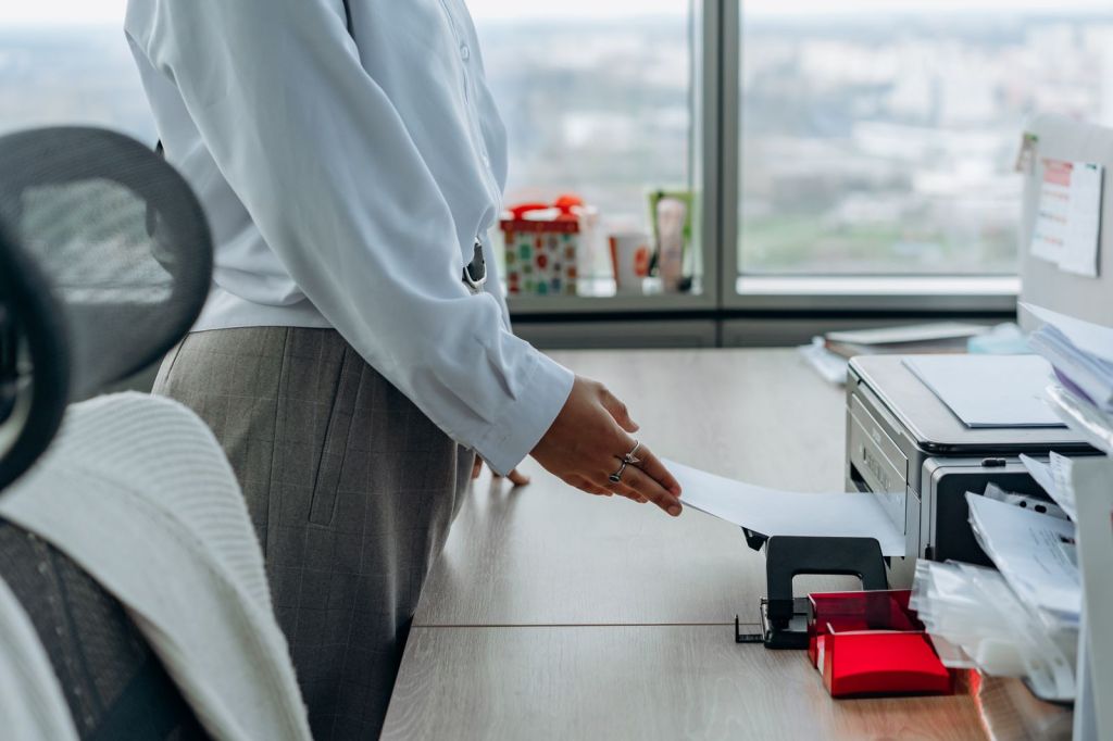 A person collecting pages from an office printer