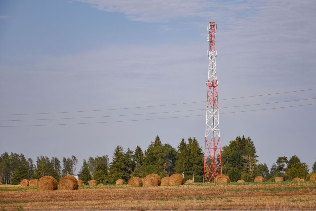 Small-town AM radio tower above farm fields in the countryside